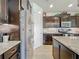 Spacious kitchen with granite counters, dark wood cabinets, stainless steel appliances, and tile floors at 5016 Bella Armonia Cir, Wimauma, FL 33598