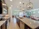 Spacious kitchen with a large island, granite counters, stainless appliances, and modern lighting at 5016 Bella Armonia Cir, Wimauma, FL 33598