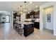Kitchen with granite countertops, dark cabinetry, stainless appliances, and a large center island with seating at 5016 Bella Armonia Cir, Wimauma, FL 33598