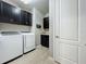 Functional laundry room with washer, dryer, storage cabinets, and utility sink at 5016 Bella Armonia Cir, Wimauma, FL 33598