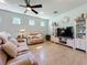 Comfortable living room with couches, a ceiling fan, entertainment center, and neutral decor, offering a cozy space at 5016 Bella Armonia Cir, Wimauma, FL 33598
