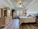 Cozy main bedroom with tray ceilings, wooden furniture, and plank floors, offering a comfortable retreat at 5016 Bella Armonia Cir, Wimauma, FL 33598