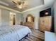 Spacious main bedroom with a tray ceiling, wooden furniture, plank floors, and ensuite bathroom entrance at 5016 Bella Armonia Cir, Wimauma, FL 33598