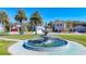 Community fountain surrounded by manicured lawns and well-maintained homes with palm trees at 5016 Bella Armonia Cir, Wimauma, FL 33598