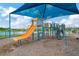 A colorful playground featuring a slide and various play structures beneath a blue shade canopy at 5016 Bella Armonia Cir, Wimauma, FL 33598