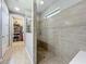 Modern tiled shower with glass paneling, and a view of a walk-in closet with shelving for organized storage at 5016 Bella Armonia Cir, Wimauma, FL 33598