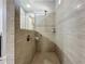 Beautifully tiled shower features modern fixtures, a tiled bench, and a half mirror at 5016 Bella Armonia Cir, Wimauma, FL 33598