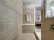 Nicely tiled shower and a view through to the vanity and bedroom, enhanced with modern fixtures at 5016 Bella Armonia Cir, Wimauma, FL 33598