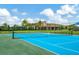 Community tennis court in great condition with view of the clubhouse at 5016 Bella Armonia Cir, Wimauma, FL 33598