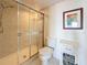 Tiled bathroom features a shower with glass door, toilet, and white storage cabinet at 5220 Brittany S Dr # 1108, St Petersburg, FL 33715