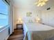 Cozy bedroom with wood floors, ceiling fan, and waterfront views from a large window at 5220 Brittany S Dr # 1108, St Petersburg, FL 33715