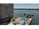 View of waterfront building, pool area with dock, lounge chairs and lush tropical landscaping at 5220 Brittany S Dr # 1108, St Petersburg, FL 33715
