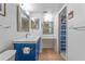 Bright bathroom featuring a modern blue vanity, large mirror, and tiled floors at 5400 Park N St # 512, St Petersburg, FL 33709