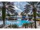 Aerial view of community pools with tropical landscaping and water slides, surrounded by palm trees at 5709 Sea Turtle Pl, Apollo Beach, FL 33572