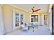 Cozy outdoor porch with ample seating, a ceiling fan, and a view of the surrounding landscape at 5709 Sea Turtle Pl, Apollo Beach, FL 33572