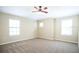 A spacious bedroom with neutral carpet, three windows for natural light, and a ceiling fan at 5710 Kingletsound Pl, Lithia, FL 33547