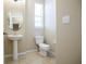 This half bathroom features a pedestal sink, toilet, large mirror, and a tile floor at 5710 Kingletsound Pl, Lithia, FL 33547