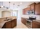 Modern kitchen with stainless steel appliances, granite countertops, and ample cabinet space with eat in breakfast bar at 5710 Kingletsound Pl, Lithia, FL 33547