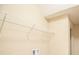 A laundry area is shown with a wire shelf above the hookups, providing practical storage in a neutral-toned space at 5710 Kingletsound Pl, Lithia, FL 33547