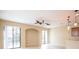 An open-concept living room featuring tile floors, an arched entryway and two sliding glass doors for natural light at 5710 Kingletsound Pl, Lithia, FL 33547