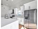 Modern kitchen features white cabinetry, stainless steel refrigerator, and marble countertops at 6475 29Th N Way, St Petersburg, FL 33702