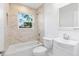 Bright bathroom with a shower-tub combo, white vanity, and tiled walls at 6690 33Rd N Ave, St Petersburg, FL 33710