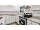 Close-up of the kitchen featuring stainless appliances, granite counters, and white cabinets at 6690 33Rd N Ave, St Petersburg, FL 33710