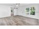 Bright living room featuring wood-look floors, ceiling fan, large windows, and a modern front door at 6690 33Rd N Ave, St Petersburg, FL 33710