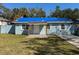Charming single-story home with a bright blue tarp on the roof, white shutters, and a well-maintained front yard at 6708 S Faul St, Tampa, FL 33616