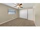 Carpeted bedroom featuring a ceiling fan, window with blinds, and a closet for optimal storage at 6901 298Th N Ave, Clearwater, FL 33761