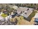 Aerial view of the home featuring a stone paver driveway, mature trees, and well manicured lawn at 7208 Baltusrol Dr, New Port Richey, FL 34654