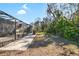 View of the backyard from the screened in back patio featuring stone pavers and lush greenery at 7208 Baltusrol Dr, New Port Richey, FL 34654