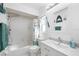 Bright bathroom with white fixtures, a shower-tub combo, and beach themed decor for a refreshing feel at 7208 Baltusrol Dr, New Port Richey, FL 34654