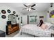 Comfortable bedroom with a ceiling fan, dresser, and a cozy queen-size bed with colorful bedding at 7208 Baltusrol Dr, New Port Richey, FL 34654
