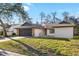 Charming single-story home with manicured lawn, neutral exterior and dark garage door, providing curb appeal at 7208 Baltusrol Dr, New Port Richey, FL 34654