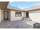 Inviting courtyard entrance features a brick paver patio and a decorative glass front door at 7208 Baltusrol Dr, New Port Richey, FL 34654