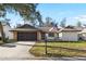 Charming single-story home featuring stone accents, neutral paint, and a well-manicured lawn at 7208 Baltusrol Dr, New Port Richey, FL 34654