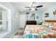 Inviting bedroom with floral bedding, complemented by light blue walls and a ceiling fan for a relaxing ambiance at 7208 Baltusrol Dr, New Port Richey, FL 34654