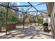This screened patio with stone pavers and a grill offers great space for entertaining at 7208 Baltusrol Dr, New Port Richey, FL 34654