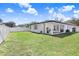 Spacious backyard with a well-manicured lawn, patio, and a white fence at 7403 Edgemere Rd, Tampa, FL 33625