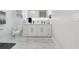 Bright bathroom with modern vanity, illuminated mirror, and marble-look tile flooring at 7403 Edgemere Rd, Tampa, FL 33625