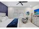 Bright bedroom with a cozy gray accent chair, complemented by a decorative guitar and dresser at 7403 Edgemere Rd, Tampa, FL 33625