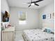 Neutral bedroom with a bed adorned with a playful, patterned comforter and coordinating throw pillows at 7403 Edgemere Rd, Tampa, FL 33625