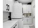 A well-organized laundry room featuring modern appliances, white cabinets, and sleek black hardware at 7403 Edgemere Rd, Tampa, FL 33625