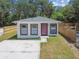 An inviting home's exterior showcasing its front yard, pink door, and newly paved driveway at 7408 Gulf Breeze Cir, Hudson, FL 34667