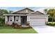Charming single-story home with a two-car garage, manicured lawn, and neutral-toned siding at 7795 Wheat Stone Dr, Zephyrhills, FL 33540
