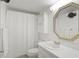 Bright bathroom featuring a shower with a white curtain and octagonal mirror at 7910 Sun Island S Dr # 302, South Pasadena, FL 33707