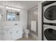 Bright bathroom featuring a stand-up shower, a vanity with great lighting, and a stackable washer/dryer at 7910 Sun Island S Dr # 302, South Pasadena, FL 33707