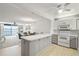 Open-concept kitchen featuring gray cabinetry, stainless appliances, and access to the dining area at 7910 Sun Island S Dr # 302, South Pasadena, FL 33707