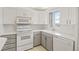 Compact kitchen featuring white appliances, a double-basin sink, and classic white cabinetry at 7910 Sun Island S Dr # 302, South Pasadena, FL 33707